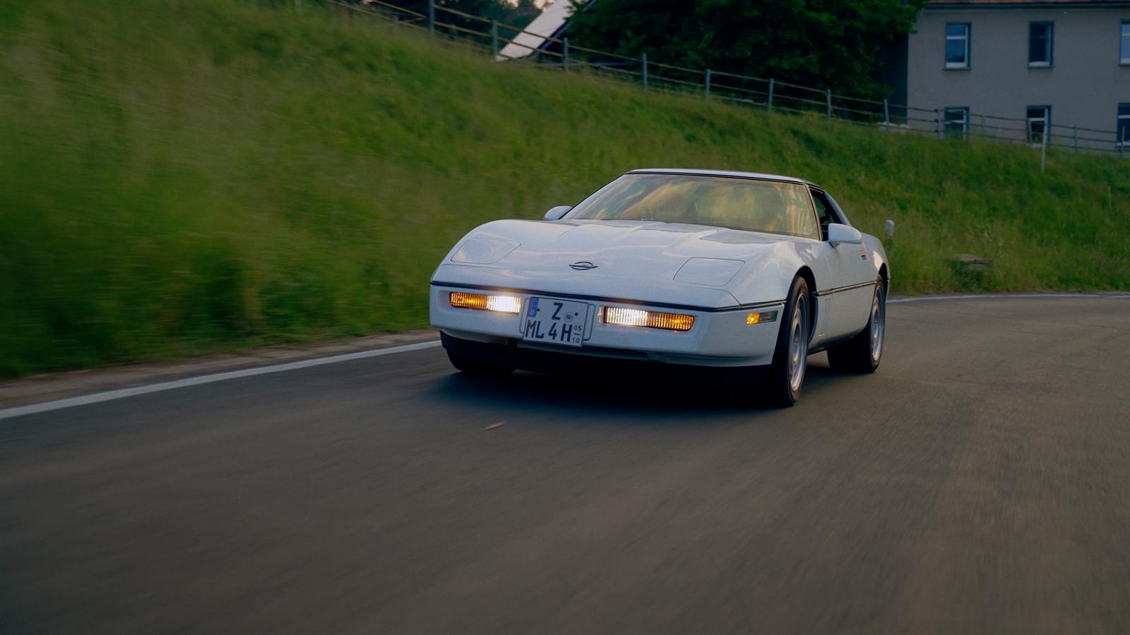 Corvette C4 auf einer Landstraße zwischen Wiesen